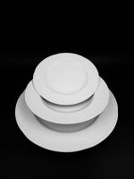 מבט על עריכה מינימליסטית ומתוחכמת של סט Bauscher Mozart, כלי הפורצלן הבהירים בולטים על רקע שחור עמוק.