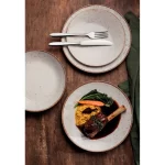 הגשת ארוחת ערב ביתית חמה בצלחות פורצלן חומות מסדרת רוסטיקו של טרמונטינה באור יום רך.