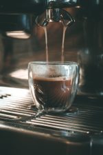כוס אספרסו דופן כפולה מתמלאת לאט לאט על ידי מכונת אספרסו