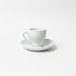 זוג ספלי אספרסו ותחתיות תואמות מפורצלן לבן על רקע נקי. מבט מהצד על סט ספל ותחתית לאספרסו בעיצוב אירופאי קלאסי.