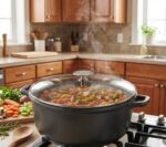 תמונת אווירה של סוטאז' Choc Extreme על כיריים דולקות עם תבשיל ירקות צבעוני. תקריב (Close-up) על אדים עולים מסיר הסוטאז' בזמן בישול איטי ומפנק.