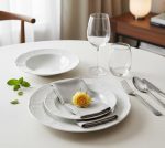 סט צלחות פורצלן Bauscher Mozart ערוך על שולחן חג מודרני, עם מפה וסכו"ם יוקרתי, ליצירת אווירת אירוח חגיגית.