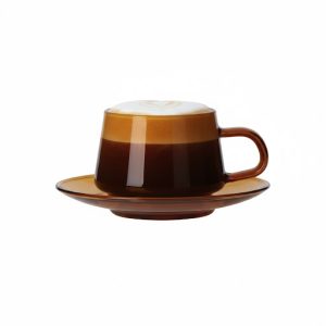 תקריב של ספל קפוצ'ינו טוקיו החום-שקוף על רקע לבן, המציג את השכבות של האספרסו, חלב חם וקצף עם אמנות עדינה על פני השטח.