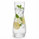 תקריב על קנקן זכוכית מלא המדגיש את צלילות הזכוכית דרך קוביות הקרח והפירות הצבעוניים.