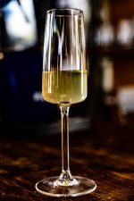 תמונה מקרוב של כוס שמפניה Grandeur מלאה, המדגישה את בועות המשקה ואת הברק של הזכוכית.