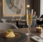כוס שמפניה קריסטל Nachtmann Noblesse (150 מ"ל) מלאה בשמפניה, מונחת על שולחן במסעדת יוקרה.