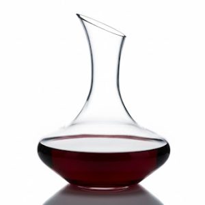 דיקנטר יין Arcoroc בנפח 1.3 ליטר , מלא ביין אדום עד בערך 20% מנפחו, מונח על רקע לבן ומדגיש את צווארו הרחב.