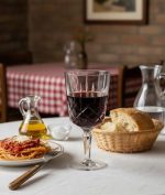 על שולחן ערוך בקפידה במסעדה, כוס Noblesse של Nachtmann עם יין אדום, המשדרת יוקרה ועידון, ומוסיפה נופך קלאסי לחוויית הסעודה.