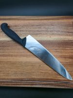 יד אוחזת בסכין שף Sico Ergoline 25, מראה את האחיזה הנוחה והבטוחה של הידית הארגונומית.