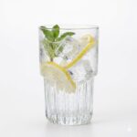 כוס היי-בול Everest של Libbey עם קוקטייל צבעוני, קוביות קרח ופלח לימון להגשה מרעננת.