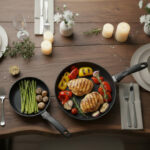 חוויית אירוח: זוג מחבתות אינדוקציה Swiss Diamond XD (20 ו-26 ס"מ) עם אוכל מוכן להגשה ישירות לשולחן עץ.