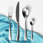 סט סכו"ם Salvinelli Forever Ice מונח על בד סאטן בגוון תכלת-טורקיז יוקרתי.