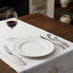 שולחן אוכל יוקרתי ערוך עם סט סכו"ם Salvinelli Forever, צלחת פורצלן וכוס יין אדום.