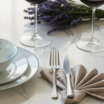 שולחן אירוח יוקרתי עם סכו"ם Salvinelli Princess Ice, צלחות פורצלן מעוטרות בכחול וזרי לבנדר.