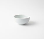 מבט צד על קערת פורצלן לבנה עמוקה עם גימור חלק וקצוות מעוגלים