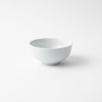 מבט צד על קערת פורצלן לבנה עמוקה עם גימור חלק וקצוות מעוגלים