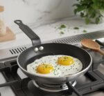 מבט מקרוב על מחבת הטיגון הקומפקטית של de Buyer בשימוש יומיומי להכנת חביתה אישית אסתטית ובריאה.