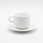 זוג ספלי קפוצ'ינו ותחתיות מפורצלן Bone China לבן של מותג העילית Arthur Krupp על רקע לבן.
